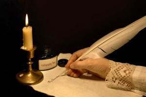 Hand writing a letter with a goose feather from DepositPhotos